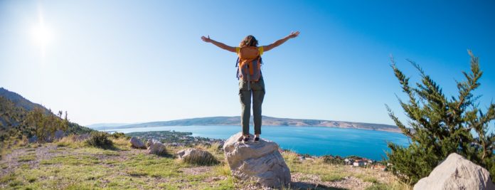 Girl on the background of the sea and mountains.