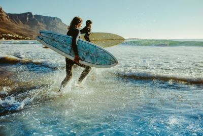 Surfer rennen ins Wasser